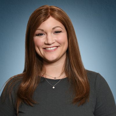 Young woman with red hair and gray shirt smiling