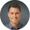 Prevention and Regrowth - a man with nice, thick hair is wearing a gray button-up shirt and is smiling directly at the camera.